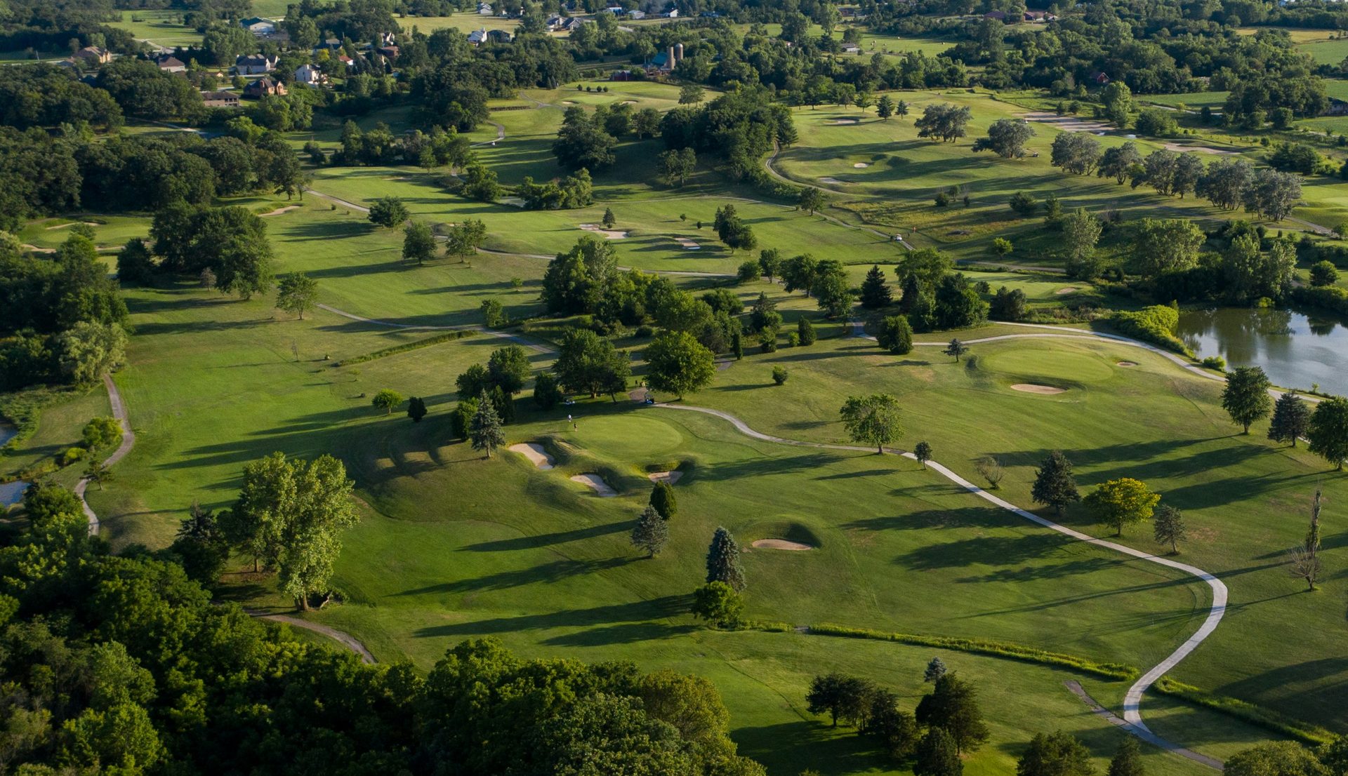 Aerial view of Oak Crest Golf Course showing rolling fairways, greens, and bunkers in Norway, Michigan